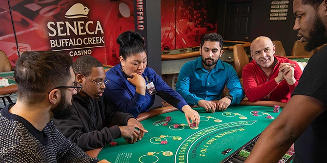 Dealers sitting at a gaming table during a training session.